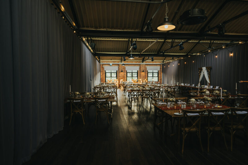 Two Brides, One Incredible Day – The Venue Bowers Mill Wedding Photography 52 Detail photo of wedding breakfast room at industrial brick wall The Venue Bowers Mill